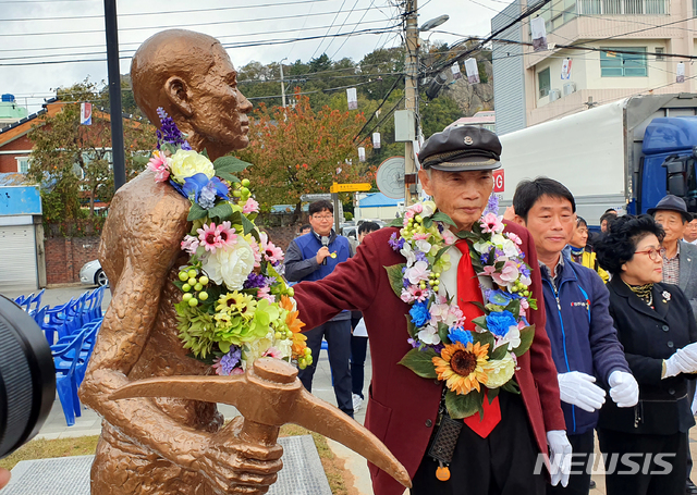 【목포=뉴시스】박상수 기자 = 13일 오후 전남 목포시 중앙동 근대역사2관 옆 소공원에서 열린 '전남 일제강점기 강제징용 노동자상' 제막식에서 징용 피해자 박정규(95) 옹이 노동자상에 꽃목걸이를 걸어주고 있다. 2019.11.13.  parkss@newsis.com 