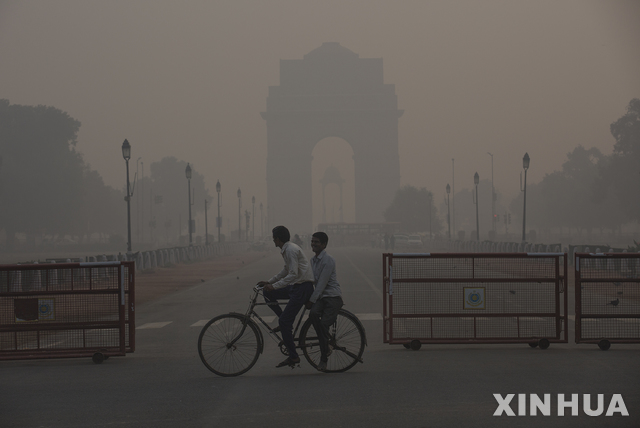 【뉴델리(인도)=신화/뉴시스】대기 오염이 극심한 인도 수도 뉴델리에서 13일 시민들이 자전거를 타고 시내를 지나가고 있다. 뉴델리의 대기 오염이 극단적 수준에 도달함에 따라 14, 15일 이틀 간 뉴델리의 모든 학교들에 또다시 강제 휴교령이 내려졌다고 인도 환경오염예방통제국(EPCA)가 13일 밤 밝혔다. 2019.11.14