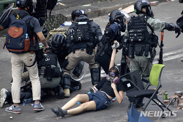 [홍콩=AP/뉴시스] 18일(현지시간) 홍콩 이공대(폴리테크닉)에서 경찰이 학교를 빠져나가려던 시위 학생을 잡아끌고 있다. 홍콩 경찰은 대학 캠퍼스를 점거한 시위대가 대학으로 진입한 경찰의 체포를 피하려 학교 탈출을 시도하는 가운데 시위 학생들을 체포하고 있다. 2019.11.18. 
