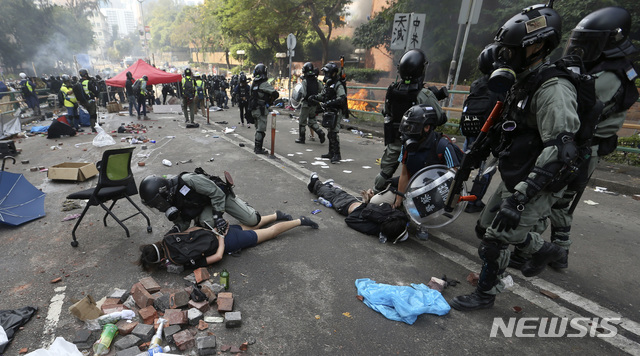 [홍콩=AP/뉴시스] 18일(현지시간) 홍콩이공대(폴리테크닉)에서 홍콩 경찰이 시위대를 체포하고 있다. 경찰에 포위돼 홍콩이공대 안에 갇혀 있던 시위대원 수십 명이 밧줄을 타고 고속도로로 내려가 탈출했다고 현지 언론이 목격자들의 말을 인용해 전했다. 앞서 17일 경찰은 캠퍼스를 탈출하려는 시위대원 400여 명을 체포했다고 밝혔으며 현재 약 100명의 시위대가 학교에 남아 있다고 전했다. 2019.11.19.