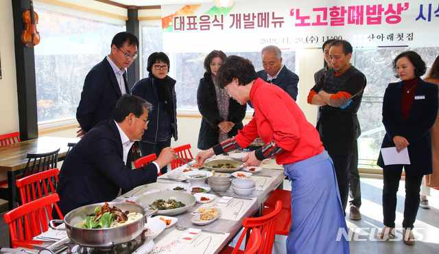 김순호 군수(왼쪽)가 음식 설명을 듣고 있다.