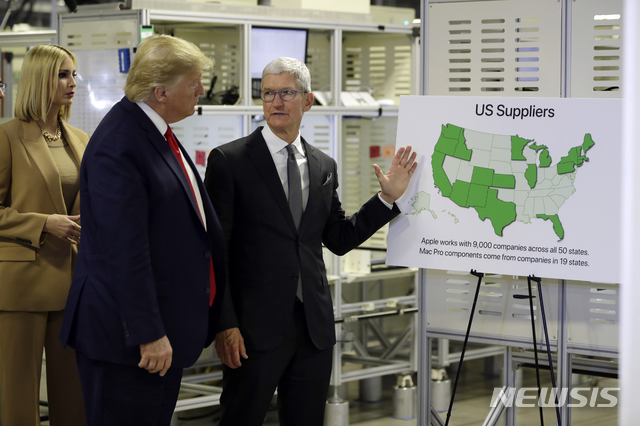 [오스틴=AP/뉴시스]도널드 트럼프 미국 대통령이 20일(현지시간) 미 텍사스주 오스틴의 애플 공장을 방문해 팀 쿡 애플 최고경영자(CEO)로부터 설명을 듣고 있다. 2019.11.21.
