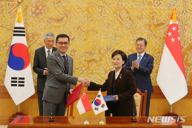 [서울=뉴시스]배훈식 기자 = 김현미 국토교통부 장관과 에릭 테오(Eric Teo) 싱가포르 주한대사 23일 청와대 본관에서 문재인 대통령과 리센룽 싱가포르 총리가 지켜보는 가운데 스마트시티 협력 MOU를 교환하고 있다. 2019.11.23.  dahora83@newsis.com