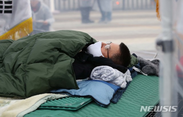 [서울=뉴시스] 고범준 기자 = 황교안 자유한국당 대표가 단식중인 24일 오후 서울 청와대 분수대 앞 광장에서 열린 자유한국당 비상 의원총회에서 국민의례를 마치고 누워 있다. 2019.11.24. bjko@newsis.com