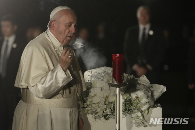 [히로시마=AP/뉴시스]24일 일본을 방문한 교황 프란치스코가 원자폭탄 피해자들을 기리는 히로시마 평화기념공원에서 촛불에 불을 붙이는 모습. 2019.11.24.