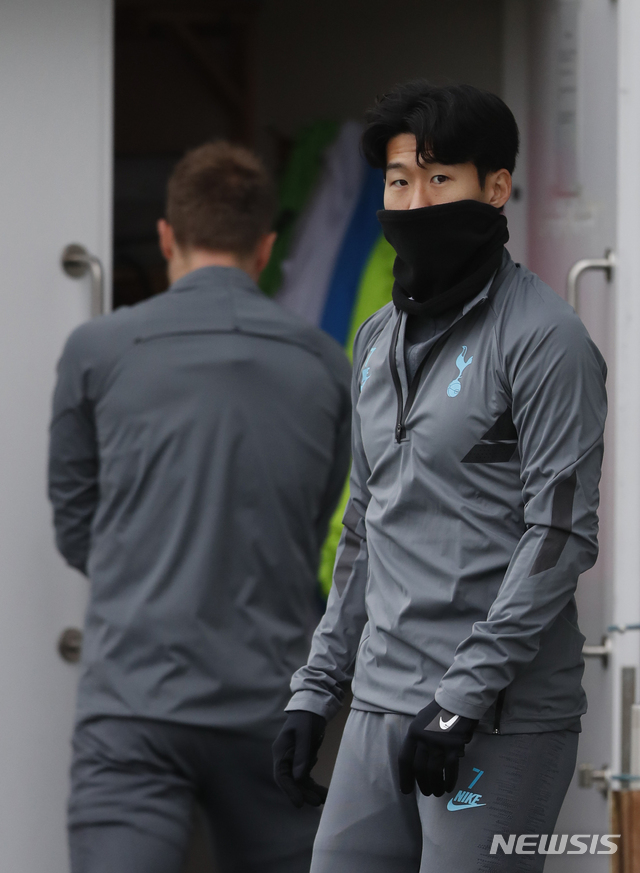 Tottenham&#039;s Son Heung-min, right wrapped up against the cold waits to start a training session for their upcoming Champions League Group B soccer match against Olympiakos at their training ground in London, Monday, Nov. 25,2019. Tottenham play Olympiakos on Tuesday. (AP Photo/Alastair Grant)