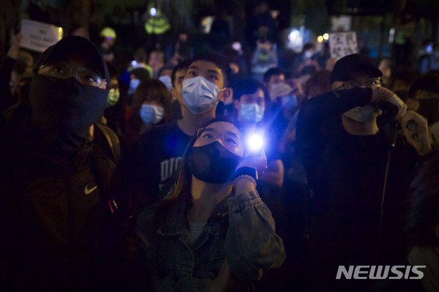 [홍콩=AP/뉴시스]마스크를 착용한 홍콩 시위대가 25일(현지시간) 반정부 시위대 최후 보루인 홍콩이공대 인근에 모여 플래시 불빛을 쏘아올리고 있다. 2019.11.26. 