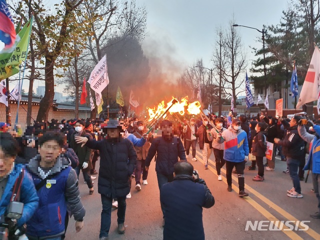 [서울=뉴시스]김정현 수습기자 = 민중공동행동 등 '2019 민중대회' 참가자들이 30일 서울 종로구 청와대 앞에서 횃불을 켜고 있다. 2019.11.30. ddobagi@newsis.com 