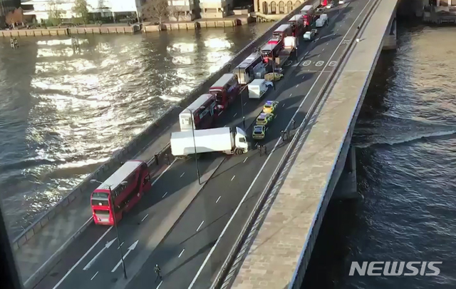 [런던=AP/뉴시스]29일(현지시간) 영국 런던의 런던브리지에서 흉기 사건이 발생해 여러 명이 다쳤다. 사진은 다리 중간에서 경찰차들이 트럭 한 대를 둘러싸고 있는 모습을 한 시민이 촬영한 것. 경찰은 이번 사건을 테러로 규정했다. 2019.11.30. 