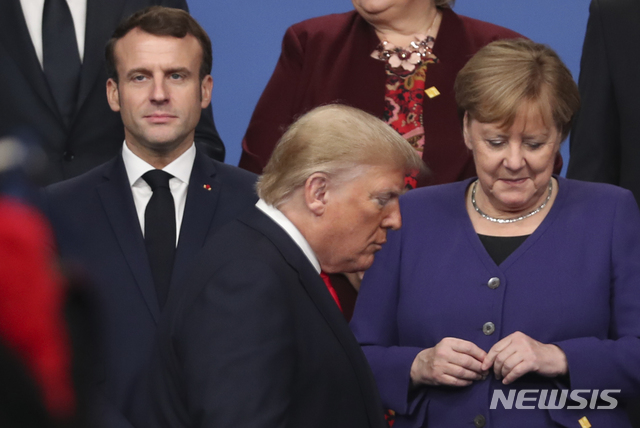 [런던=AP/뉴시스] 2019년 12월 4일(현지시간) 나토(NATO·북대서양조약기구) 정상회의에서 도널드 트럼프 미국 대통령(가운데)이 에마뉘엘 마크롱 프랑스 대통령(왼쪽)과 앙겔라 메르켈 독일 총리 앞을 지나가고 있다. 2019. 12. 04.  