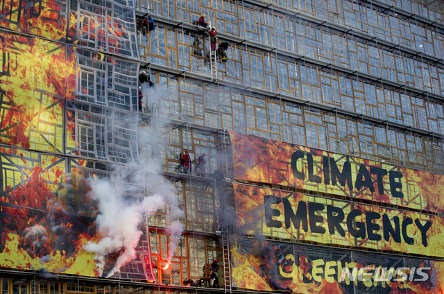 [브뤼셀=AP/뉴시스]국제환경단체 그린피스 활동가들이 12일(현지시간) 유럽연합(EU) 정상회의가 열릴 예정인 벨기에 브뤼셀의 EU 본부에서 건물 외벽을 타며 기후 변화 시위를 벌이고있다. 이들은 건물에 '기후 비상'이라는 배너를 내걸었다. 2019.12.13.