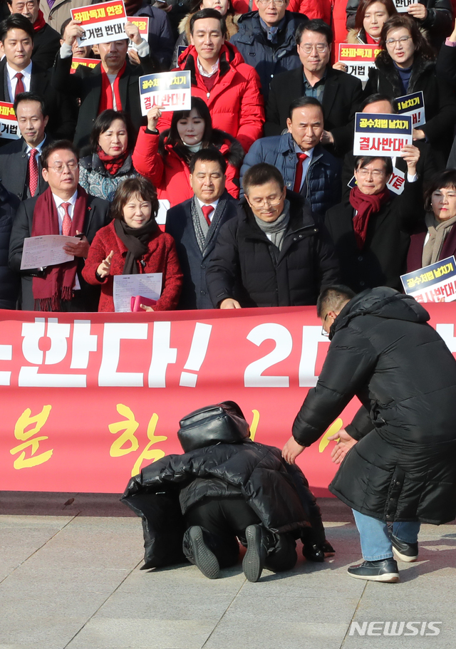 [서울=뉴시스]김명원 기자 = 자유한국당 황교안 대표와 의원들이 16일 오전 서울 여의도 국회 본청 계단앞에서 공수처법 선거법 날치기 저지 규탄대회중 한 당원이 큰절을 하고 있다. 2019.12.16. kmx1105@newsis.com