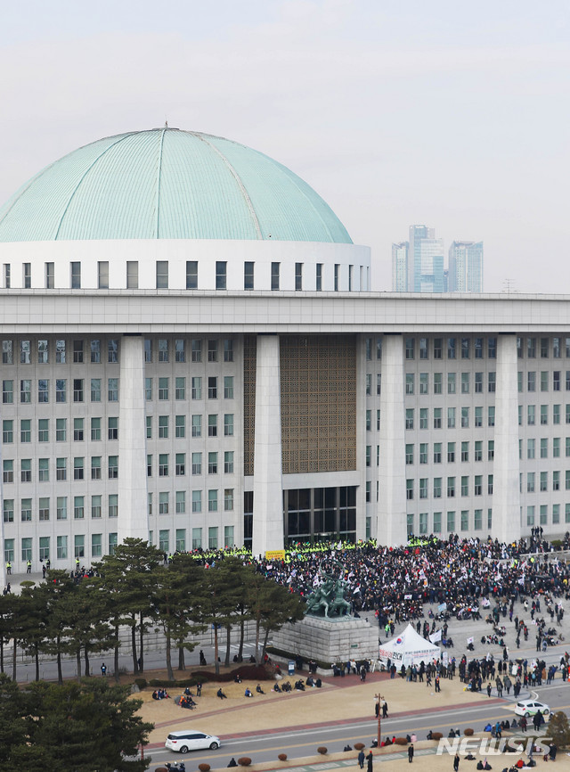 [서울=뉴시스] 장세영 기자 = 우리공화당 당원 등 보수단체 회원들이 16일 오전 서울 여의도 국회 본청 앞에서 태극기와 함께 공수처법, 선거법 반대 등이 적힌 손 팻말을 들고 구호를 외치고 있다. 2019.12.16.  photothink@newsis.com