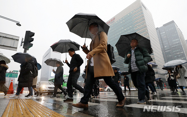 [서울=뉴시스] 이영환 기자 = 시민들이 비가 내린 17일 오전 서울 종로구 광화문 네거리에서 우산을 쓰고 출근길 발걸음을 재촉하고 있다. 2019.12.17.     20hwan@newsis.com