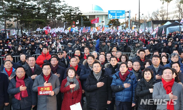 [서울=뉴시스] 고승민 기자 = 자유한국당 황교안 대표와 심재철 원내대표 등 의원들과 지지자들이 19일 서울 여의도 의사당대로에서 열린 선거법 및 공수처법 규탄대회에서 국민의례를 하고 있다. 2019.12.19.photo@newsis.com