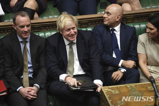 In this photo made available by the UK Parliament, Britain's Prime Minister Boris Johnson, center, attends the debate in the House of Commons, London, Thursday Dec. 19, 2019. Boris Johnson signaled an end to Britain’s era of Brexit deadlock Thursday, announcing a packed legislative program intended to take the U.K. out of the European Union on Jan. 31, overhaul everything from fishing to financial services and shore up the country’s cash-starved public services. (Jessica Taylor/UK Parliament via AP)