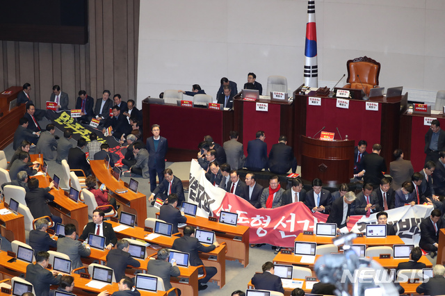 [서울=뉴시스] 고승민 기자 = 자유한국당 의원들이 27일 서울 여의도 국회에서 제373회국회(임시회) 제1차 본회의가 열리기 전 문희상 의장이 회기 결정 안건을 상정하기에 앞서 지난 필리버스터를 마친 선거법에 대한 표결을 먼저 처리할 것으로 알려지자 회기 결정 안건 선표결을 촉구하며 의장석을 둘러 앉아 농성을 하고 있다. 2019.12.27. kkssmm99@newsis.com