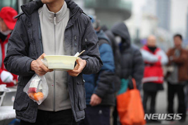 [서울=뉴시스] 노숙인이 무료 배식한 음식을 들고 이동하는 모습. 사진은 기사와 무관. (사진=뉴시스DB)