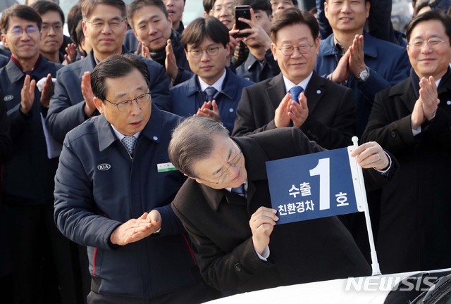 [평택=뉴시스]배훈식 기자 = 문재인 대통령이 3일 평택항에서 2020년 친환경차 수출 1호 '니로'에 기념 깃발을 달아주고 있다. 2020.01.03.  dahora83@newsis.com