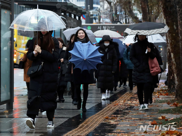 [서울=뉴시스]이윤청 기자 = 약한 비가 내리는 지난달 8일 오전 서울 시청역 인근에서 시민들이 우산을 쓰고 걷고 있다. 2020.01.08. radiohead@newsis.com