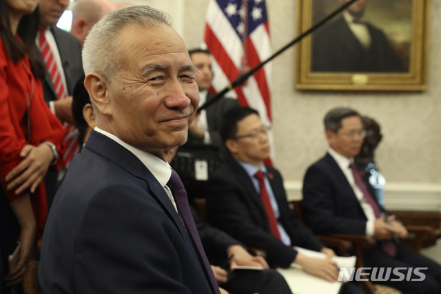 FILE - In this Oct. 11, 2019, file photo, Chinese Vice Premier Liu He listens during a meeting in the Oval Office of the White House with President Donald Trump in Washington. China&#039;s government says its Liu will go to Washington next week for the signing of an interim trade deal. (AP Photo/Andrew Harnik, File)