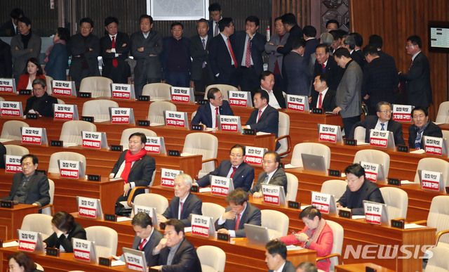 [서울=뉴시스] 김진아 기자 = 심재철 자유한국당 원내대표 등이 13일 오후 서울 여의도 국회 본회의장에서 열리는 제375회 국회(임시회) 제1차 본회의에 앞서 '검찰학살, 추미애 퇴진'이 적힌 손팻말을 모니터에 붙여두고 있다. 2020.01.13. bluesoda@newsis.com