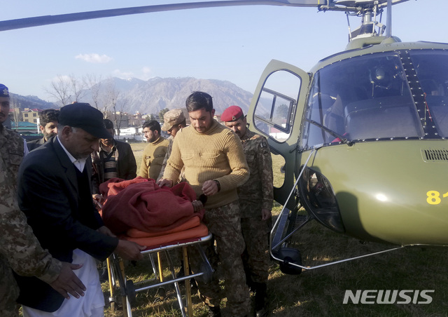 [무자파라바드=AP/뉴시스] 14일 파키스탄령 카슈미르에서 파키스탄 병사들이 눈사태 부상자를 헬기장에서 옮기고 있다  2020.01.14
