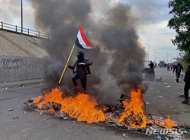 [바그다드=AP/뉴시스] 이라크 반정부시위대가 21일(현지시간) 바그다드에서 주요 고속도로를 봉쇄하기 위해 불을 지르고 있다. 2020.01.22