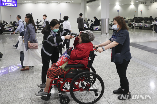 [홍콩=AP/뉴시스] 홍콩 공항에서 23일 한 보건 당국자가 한 승객의 체온을 재고 있다. 홍콩에서 우한발 폐렴에 감염된 5번째 확진자가 나오면서 당국이 방역을 강화하고 있다. 2020.01.23