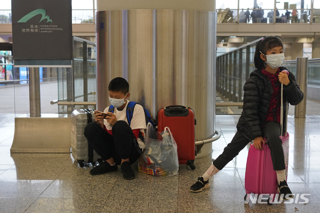 [홍콩=AP/뉴시스] '우한발 폐렴' 공포가 확산되는 가운데 25일 홍콩 공항에서 두 어린이가 마스크가 쓰고 항공기 탑승을 기다리고 있다. 2020.01.27 