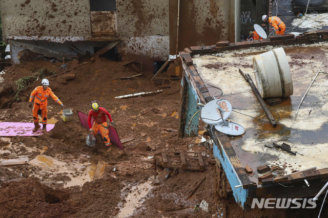 [ 바레이루( 브라질)= AP/뉴시스] 브라질의 미나스 제라이스주 바레이루에서 심한 폭우로 산사태가 일어나 25일(현지시간) 소방구조대가 무너진 집터들의 진흙 속에서 희생자를 수색하고 있다.  110년만의 폭우로 현재 사망자는 총 53명에 이르렀다.    