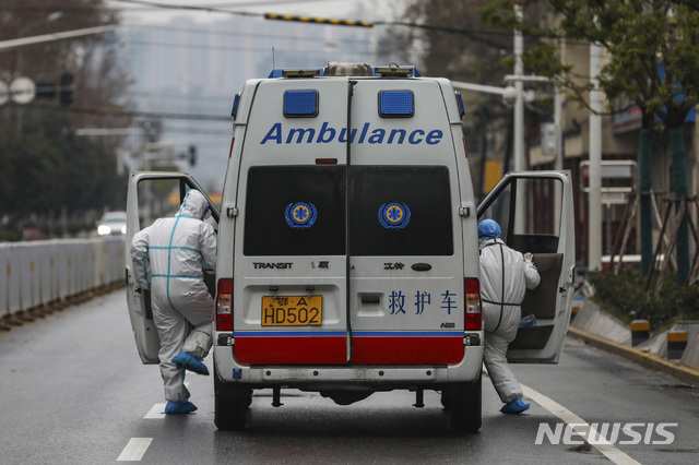 [우한=AP/뉴시스]중국 후베이성 우한에서 26일 보호복을 입은 구급대원들이 폐렴환자를 수송하기 위해 앰뷸런스에 올라타고 있다. 2020.01.27