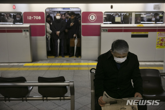 [도쿄=AP/뉴시스]일본 도쿄 지하철 내에서 28일 오전 한 시민이 마스크를 쓰고 열차가 도착하기를 기다리며 신문을 읽고 있다. 우한 폐렴으로 불리는 신종 코로나바이러스 감염증이 전세계로 확산하면서 마스크 착용 등 예방법에 대한 시민들의 관심이 높아지고 있다. 2020.01.28.