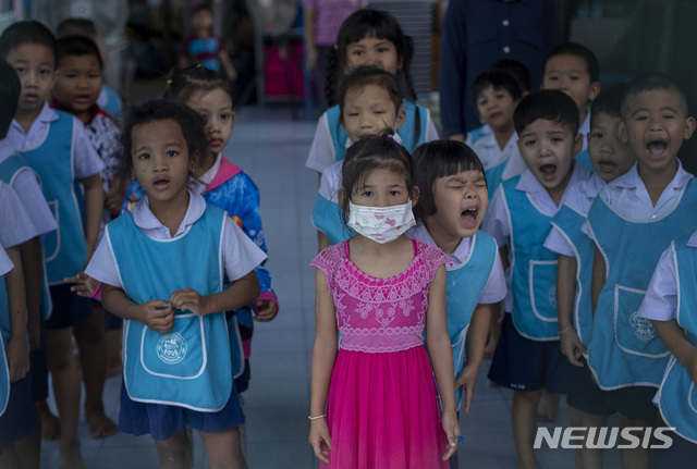 [방콕(태국)=AP/뉴시스]태국 수도 방콕의 한 유치원에서 28일 마스크를 착용한 한 여자아이가 다른 원생들과 함께 국가를 부르고 있다. 태국 보건부는 이날 중국 후베이성 우한에서 시작된 신종 코로나바이러스 감염증(우한 폐렴) 환자 6명이 추가로 확인돼 태국 내 환자 수가 14명으로 증가했다고 밝혔다. 이들 6명은 모두 중국 우한 출신 관광객들로 며칠 전 태국에 입국했다. 2020.1.28