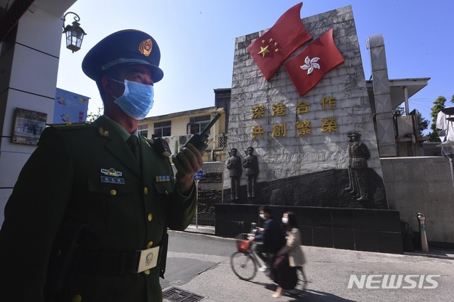 [선전=AP/뉴시스] 27일(현지시간) 신종 코로나바이러스가 퍼지고 있는 중국의 광둥성 선전시에서 한 경찰이 마스크를 쓴 채 서있다. 2020.01.29. 