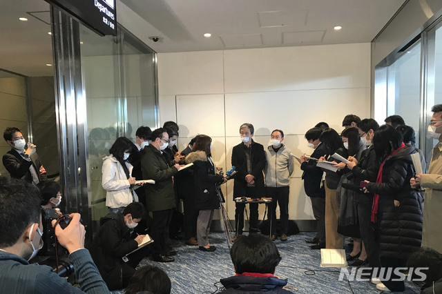 [도쿄=AP/뉴시스]중국 우한에서 전세기 편으로 29일 귀국한 일본 철강 직원들이 마스크를 쓰고 도쿄 하네다 국제공항에서 기자들에게 얘기하고 있다. 일본 정부는 중국 후베이성 우한 내 자국민 귀국 희망자 650명에 대해 전세기를 마련해 1진으로 206명이 돌아왔다. 2020.01.29.