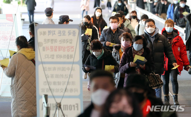 [인천공항=뉴시스] 고범준 기자 = 우한 폐렴(신종 코로나바이러스 감염증)에 대한 불안이 확산되고 있는 29일 인천국제공항 제1터미널에서 건강상태질문서를 든 중국발 항공기 이용객들이 발열검사를 위해 이동하고 있다. 2020.1.29.  photo@newsis.com