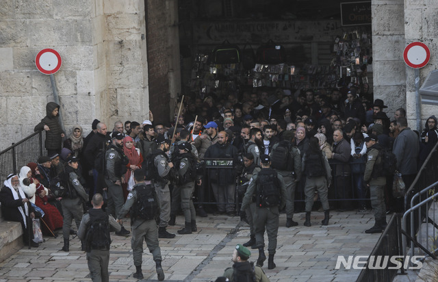 [예루살렘=AP/뉴시스]지난 1월29일(현지시간) 예루살렘에서 팔레스타인 사람들이 도널드 트럼프 미국 대통령의 '중동 평화안'에 반대하는 시위를 벌이기에 앞서 이스라엘 국경 경찰이 구시가지 다마스쿠스 문 출구를 봉쇄하고 있다. 2020.01.30.