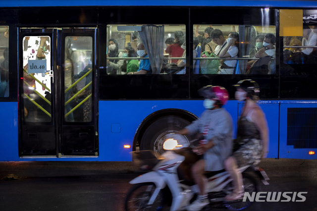 [방콕=AP/뉴시스]지난달 31일 태국 방콕에서 마스크를 쓴 승객들이 탑승한 버스 옆으로 역시 마스크를 쓴 오토바이 운전자가 지나가고 있다. 태국 보건부는 2일(현지시간) 독감과 에이즈바이러스(HIV) 치료에 쓰이는 항바이러스제 혼합물로 신종 코로나바이러스 감염증(우한 폐렴) 확진자 치료에 성공했다고 밝혔다. 2020.02.03.