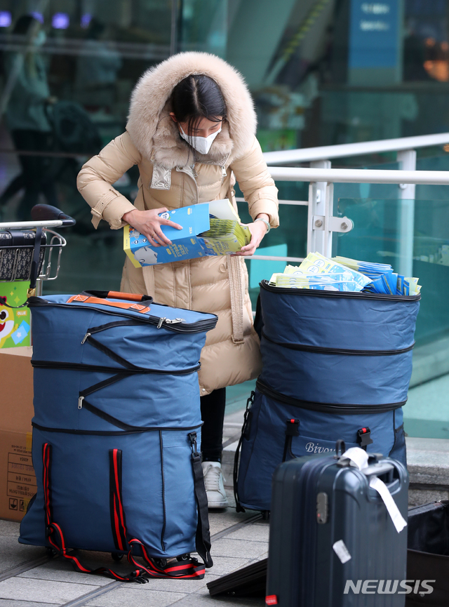 [인천공항=뉴시스]전신 기자 = 신종 코로나바이러스 감염증(우한 폐렴) 확산에 따른 마스크 품귀 현상이 빚어지는 가운데 4일 인천국제공항 출국장 앞에서 한 중국인이 대량의 마스크를 가방에 담고 있다. 2020.02.04. photo1006@newsis.com