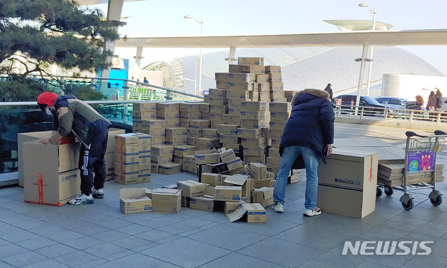 [인천공항=뉴시스]홍찬선 기자 = 신종 코로나바이러스 감염증(우한 폐렴) 여파로 마스크 품귀 현상이 이어지고 있는 5일 오후 인천국제공항 1터미널에서 홍콩인들이 마스크 제품(180박스)을 가져가기 위해 택배회사 상자로 옮겨 담고 있다. 2020.02.05. mania@newsis.com 