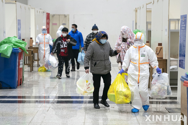 [우한=신화/뉴시스]5일(현지시간) 중국 후베이성 우한의 한 전시장을 개조한 임시병원에 신종 코로나바이러스 감염증(우한 폐렴) 환자들이 의료진의 도움으로 입원하고 있다. 현지 관계자는 우한시에서 전시장을 개조한, 1600병상 규모의 첫 임시 병원이 신종 코로나 환자를 받기 시작했다고 전했다. 2020.02.06.  