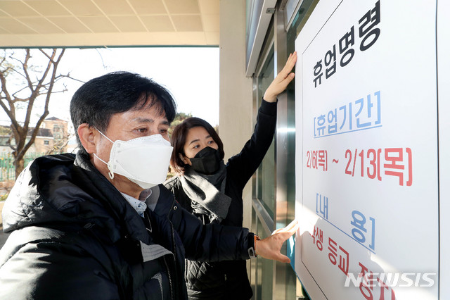 [서울=뉴시스]김병문 기자 = 신종 코로나바이러스 감염증(우한 폐렴) 확진자가 방문한 서울 중랑구와 성북구 관내 유치원과 초중고교 42개교에 대해 서울시교육청이 6일부터 13일까지 휴업 명령 내린 가운데 6일 오전 서울 성북구 삼선중학교 관계자들이 휴업 안내문을 부착하고 있다. 2020.02.06. dadazon@newsis.com