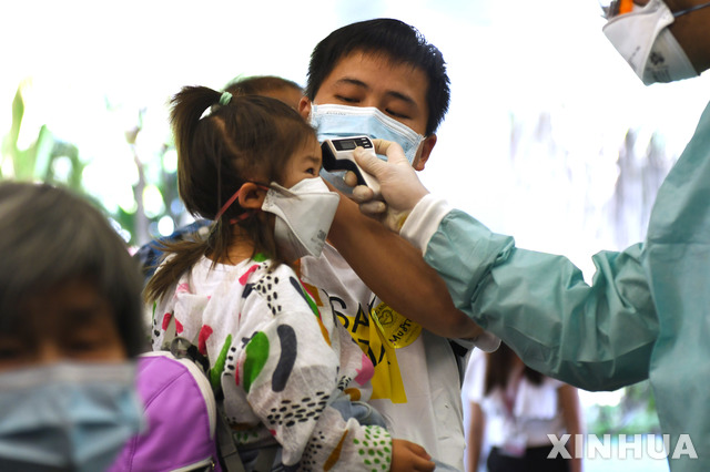 [싱가포르=신화/뉴시스] 지난 2월6일(현지시간) 싱가포르 창이 국제공항에서 신종 코로나바이러스 감염증(코로나19) 검사를 위해 직원이 아이의 체온을 재고 있다. 2020.04.20