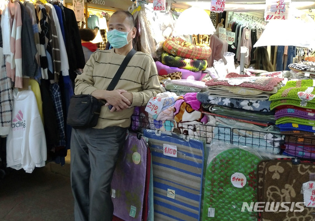 [타이베이=AP/뉴시스]6일(현지시간) 대만 타이베이의 한 야시장에서 마스크를 쓴 한 상인이 손님을 기다리고 있다. 2020.02.07. 