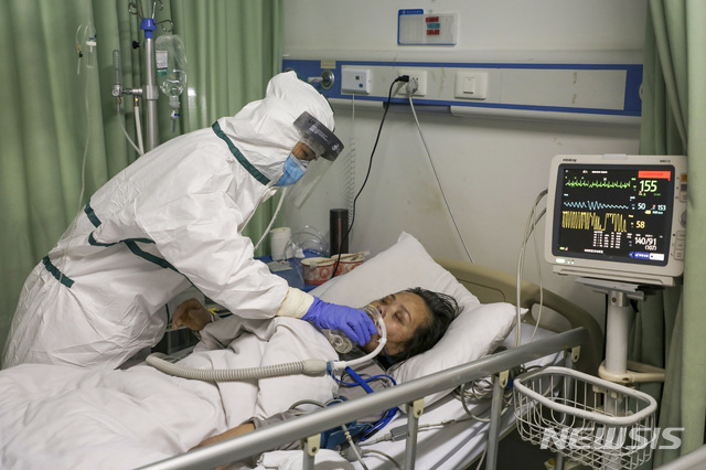 [우한=AP/뉴시스] 중국 후베이성 우한의 한 병원에서 6일 보호복을 입은 간호사가 코로나 19 환자를 돌보고 있다. 2020.02.13 