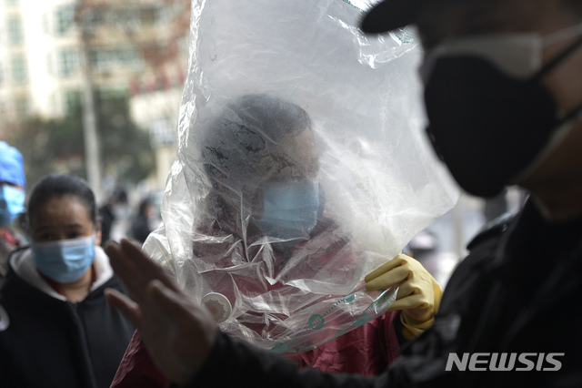 [우한=AP/뉴시스] 중국 후베이성 우한에서 10일 한 남성이 마스크를 쓰고 비닐봉지까지 뒤집어쓴채 슈퍼마켓에 들어서고 있다 .2020.02.13 