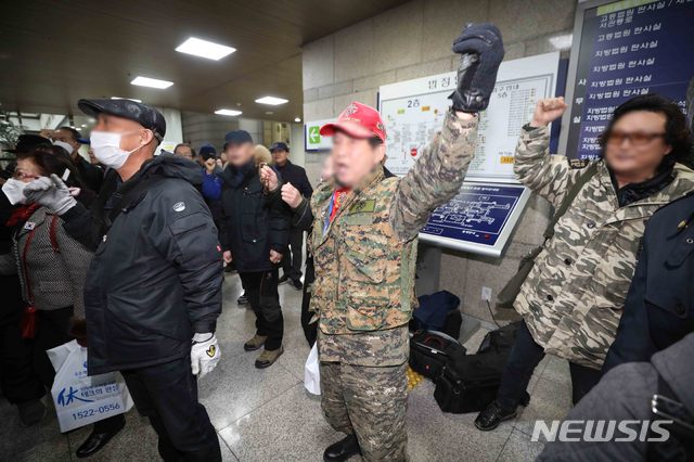 [서울=뉴시스]김선웅 기자 = 5.18 북한군 개입설을 주장한 지만원 씨에 대한 1심 징역 2년이 선고된 13일 오후 서울 서초구 서울중앙지법에서 지 씨 측 지지자들이 무죄를 주장하며 방청에 참석한 5월단체 관계자들을 향해 구호를 외치고 있다. 2020.02.13.  mangusta@newsis.com