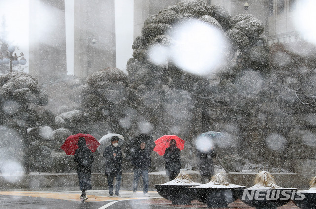 [서울=뉴시스] 장세영 기자 = 많은 눈이 내리는 16일 서울 여의도 국회에서 시민들이 우산을 쓰고 지나가고 있다. 2020.02.16.  photothink@newsis.com