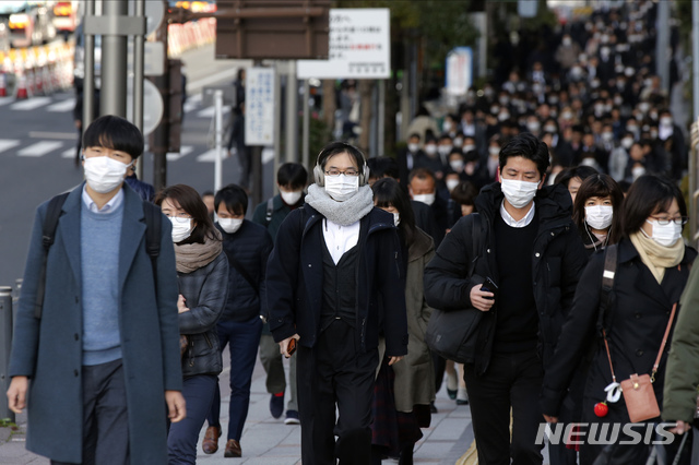 [도쿄=AP/뉴시스]20일 아침 일본 도쿄 추오구에서 시민들이 마스크를 쓴 채 출근하고 있다. 2020.02.20.